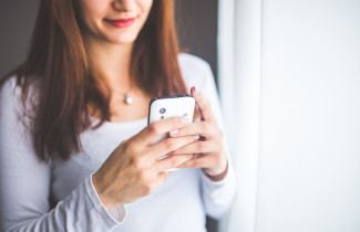 Nuori nainen katsoo kännykkää.