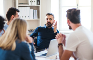 Tiimityöskentelyä yhteisen pöydän ympärillä.