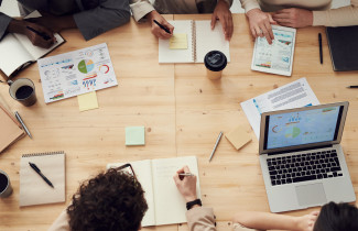 Ihmisiä työskentelemässä pöydän äärellä