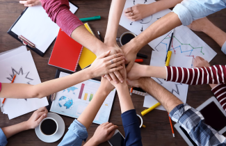 Lasten kädet pöydän päällä.