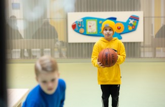 Kaksi poikaa leikkivät pallolla.