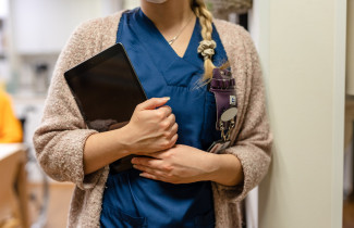 Sote-ammattilainen tablettilaite kädessään.