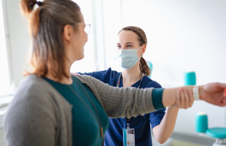 Ammattilainen antaa voimisteluohjeita käsivarren liikkuvuuteen asiakkaalle.