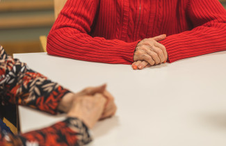 Kaksi henkilöä istuu pöydän ääressä. 