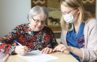 Kaksi naista juttelee ja täyttää lomaketta.