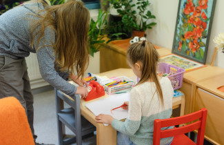 Lapsi ja vanhempi piirrustuspyödän äärellä.