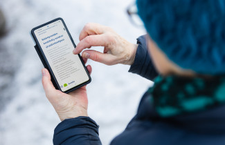 Ikääntynyt henkilö vierailee hyvinvointialueen verkkosivuilla.
