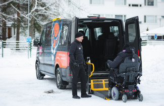 Pyörätuolia käyttävä henkilö menossa taksiin.