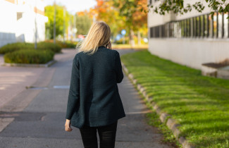 Henkilö kävelee kadulla ja puhuu matkapuhelimeen.