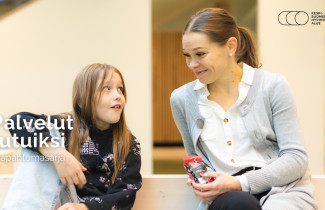 Lapsi ja aikuinen juttelevat toistensa kanssa.