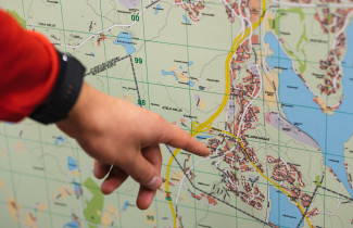 Sormi osoittamassa karttaa