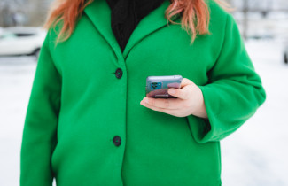 Henkilö pitää kädessään puhelinta