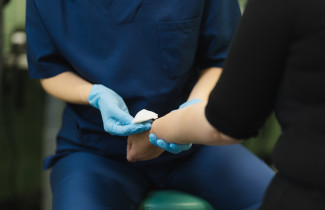 Hoitaja auttaa potilasta.