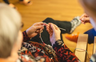 Henkilö kutoo puikoilla.