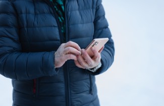 Henkilö kädessään matkapuhelin.