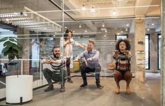 Ihmiset pitävät taukoa toimistotyöstä tekemällä kyykkyjä.