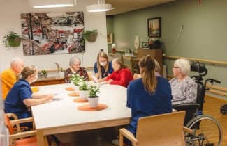 Ikäihmiset kokoontuneina saman pöydän ääreen