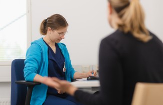 Hoitaja ja asiakas istuvat vastatusten
