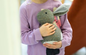 Lapsi pitää pehmolelua sylissään.