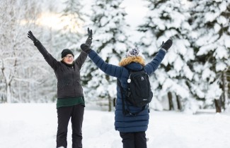 Kaksi henkilöä jumppaa talvimaisemissa