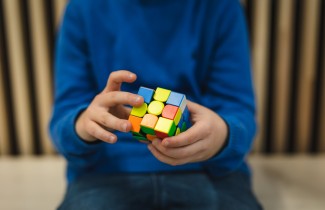 Lapsi pelaa Rubikin kuutio -peliä.