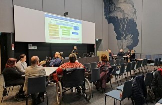 Vaikuttamistoimielimen edustajia kokoontuneena katsomaan yhteistä diaesitystä.