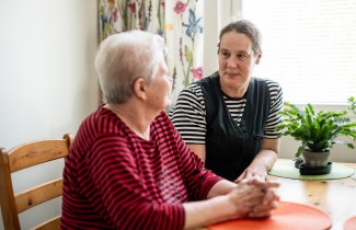 Kaksi henkilöä katsoo toisiinsa ja juttelee.