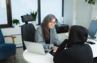 Sosiaalityöntekijä keskustelee nuoren aikuisen asiakkaan kanssa