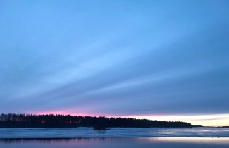 Talvinen auringonlasku järvellä.