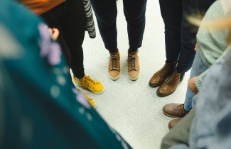 Ringissä seisovien ihmisten jalat ja kengät näkyvät