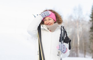 Aikuinen hiihtämässä talvisessa maisemassa.