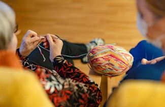 Henkilö virkkaa värikkäästä langasta.