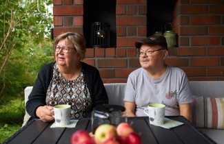 Iäkäs pariskunta istuu kotinsa terassilla.