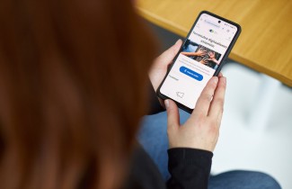 Henkilö pitää käsissään älypuhelinta