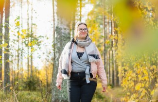 Nainen kävelee syksyisessä metsässä.