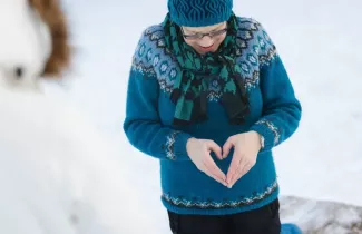 Henkilö tekee käsillään sydämen.