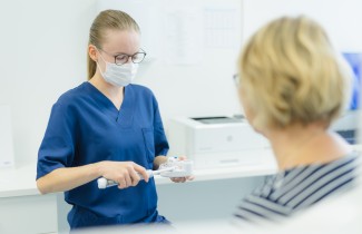 Hoitaja palvelee asiakasta.