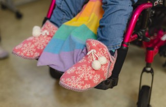 Henkilö istuu pyörätuolissa.