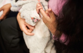 Vauvaa puristaa äitinsä sormea.