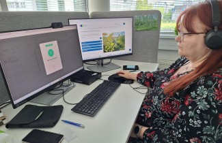 Etähoivan työntekijä työpisteessään tietokoneen ääressä.