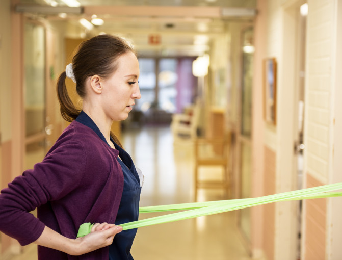 Anne-Mari Laine avustaa ikäihmistä ruokailussa