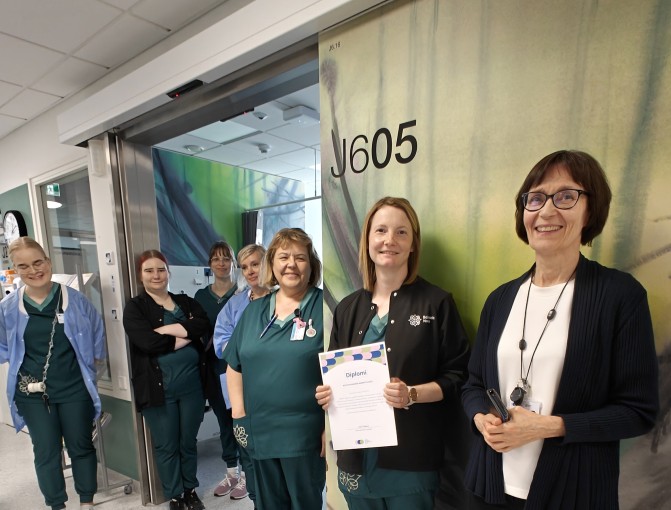 Kirsi Piitulainen ja Novan kotiutusyksikön työntekijät hymyilevät rivissä.