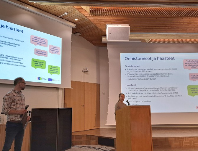 Juontaja ja esittelijä lavalla seminaarissa.