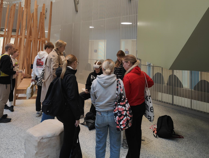 Opiskelijat testaavat VR-laseja, yleisöä seuraa ympärillä. 