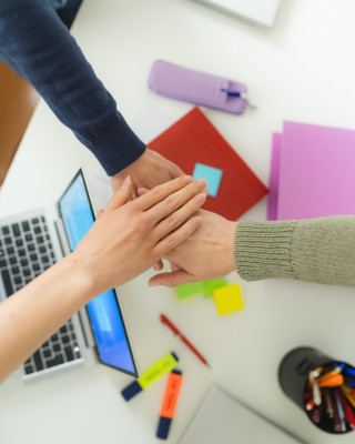 Kädet työpöydän yllä.