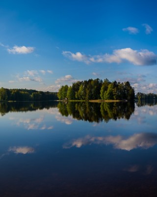 Keskisuomalainen järvimaisema, tyyni järvi, veteen heijastuva taivas ja saari
