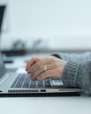 Henkilö kirjoittaa tietokoneella