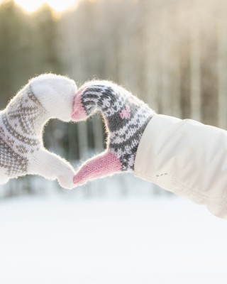 Kaksi henkilöä muodostaa lapaset kädessä sydämen