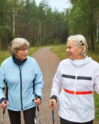 Kaksi naista sauvakävelylenkillä.
