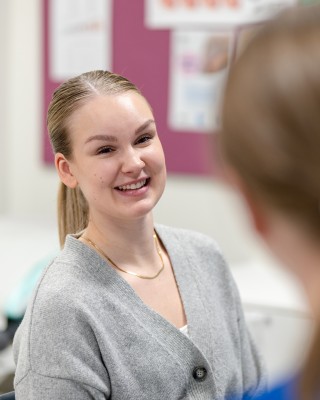 Hymyilevä henkilö terveydenhoitajan vastaanotolla äitiysneuvolassa